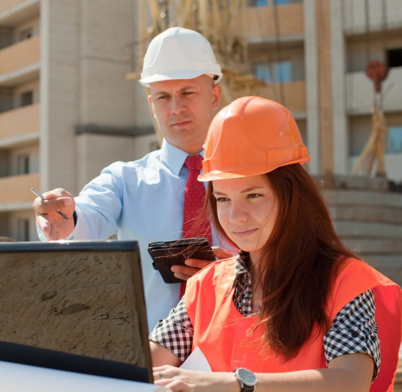 White-collar workers wearing protective helmet works on the building site