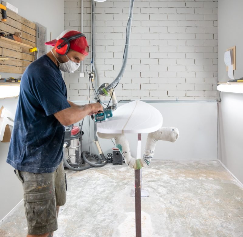 Surfboard shaper workshop - man checking quality of surfboard